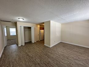 New Bern apartment for rent - an empty living room with wood flooring and white walls