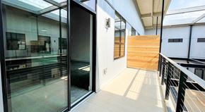 Greenville apartment for rent - A glass door is open to a hallway with a wooden wall at Judson Mill Lofts and The Jenny & Westervelt in Greenville, SC