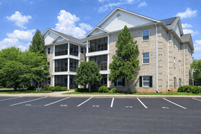Elon townhouse for rent - A large building with a parking lot in front.