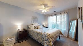 Matthews apartment for rent - a bedroom with a bed and a ceiling fan