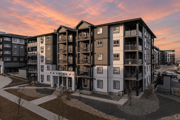 Calgary apartment for rent - A modern apartment complex with a mix of white and dark exterior walls.