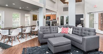 Henrico apartment for rent - a living room with a gray couch and a table and chairs