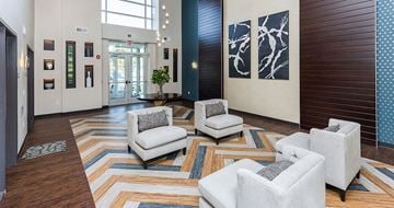 Johnston apartment for rent - A living room with a striped rug and two white chairs.