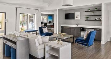 Naples apartment for rent - A modern living room with a white sofa and a blue chair.