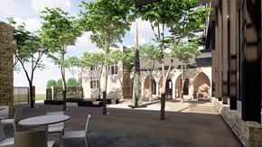 Des Moines apartment for rent - a courtyard with trees and tables and a building in the background