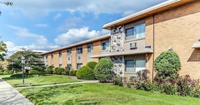 Waukegan apartment for rent - a brick apartment building with a green lawn and walkway