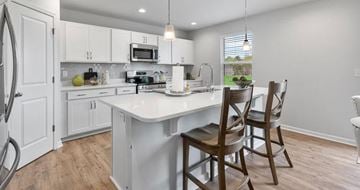 Wingate apartment for rent - A kitchen with white cabinets and a white island with a sink.