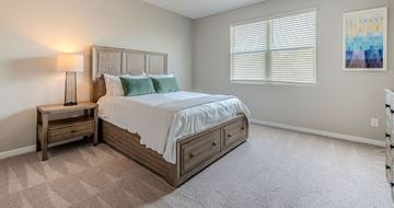 Phoenix apartment for rent - A bedroom with a large bed and a nightstand with a lamp.