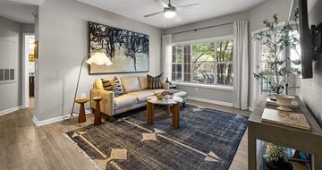 Atlanta apartment for rent - A living room with a white sofa and a large abstract painting on the wall.