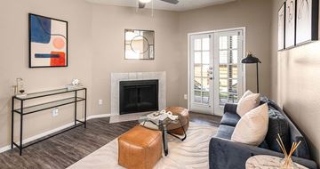 Mesquite apartment for rent - A living room with a fireplace, a couch, and a painting on the wall.