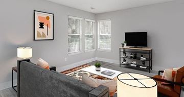 Raleigh apartment for rent - A living room with a grey couch, a white table, and a television on a stand.