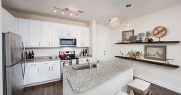 Pensacola apartment for rent - a kitchen with white cabinets and a granite counter top