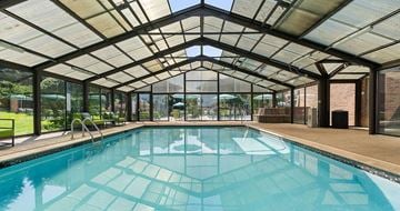 Gurnee apartment for rent - A swimming pool inside a building with a glass ceiling.