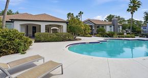 North Port apartment for rent - A pool with a sun lounger and a house in the background.