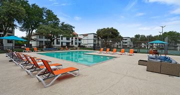 Arlington apartment for rent - A pool with orange chairs and a blue umbrella.