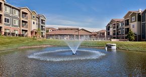 Papillion apartment for rent - a fountain in the middle of a pond in front of an apartment building