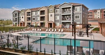 Papillion apartment for rent - A large apartment complex with a pool in the foreground.