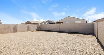 Phoenix apartment for rent - A gravel yard with a fence and a building in the background.