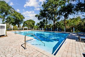 Orlando apartment for rent - A pool surrounded by trees and a sign that says
