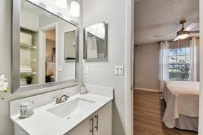 Orlando apartment for rent - a bathroom with a sink and a mirror and a bedroom with a bed