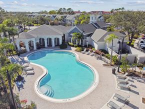 Brandon apartment for rent - A large swimming pool surrounded by a patio area with lounge chairs.