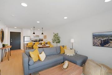 Kelowna apartment for rent - A living room with a grey couch and yellow pillows.