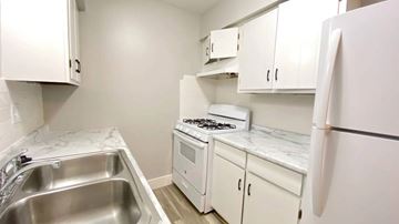 Bellevue apartment for rent - A kitchen with white cabinets and a stove top oven.
