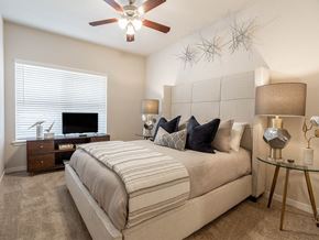Oklahoma City apartment for rent - a bedroom with a large bed and a ceiling fan