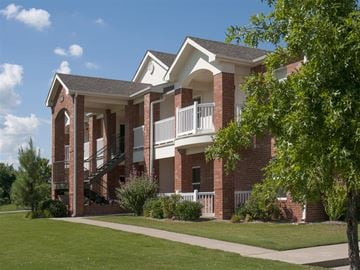 Bentonville apartment for rent - A red brick house with a white balcony.