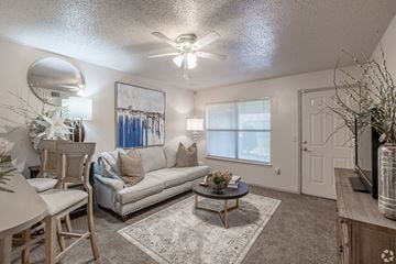 Benton apartment for rent - A living room with a white couch and a ceiling fan.