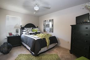 Broken Arrow apartment for rent - A bedroom with a bed, dresser, and ceiling fan.