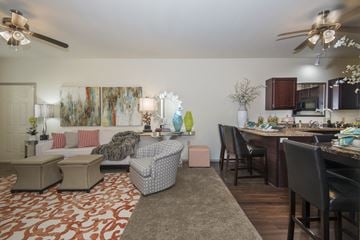 Benton apartment for rent - A living room with a patterned carpet and a kitchen area in the background.