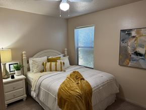 Russellville apartment for rent - A bedroom with a white bed and a yellow blanket.