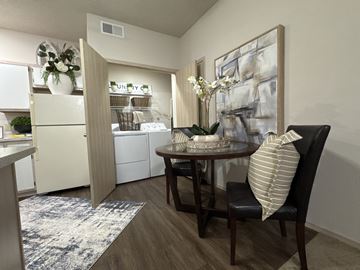 Bryant apartment for rent - A kitchen with a table and chairs in the foreground and a refrigerator with a sign that says "UNITY" on it in the background.