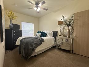 Bryant apartment for rent - A bedroom with a bed, dresser, and ceiling fan.