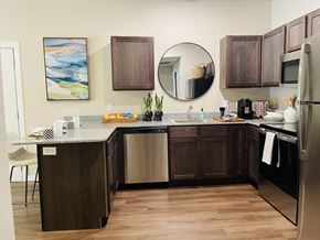 Fayetteville apartment for rent - A kitchen with dark wood cabinets and a white counter.