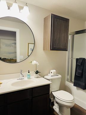 Fayetteville apartment for rent - A bathroom with a toilet, sink, mirror, and a towel hanging on the door.