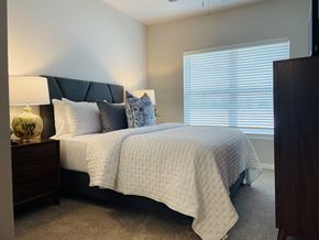 Fayetteville apartment for rent - A bedroom with a bed, nightstand, and window.