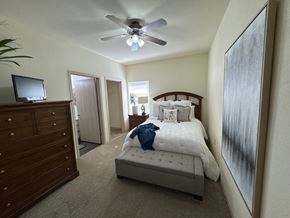 Conway apartment for rent - A bedroom with a bed, dresser, and ceiling fan.
