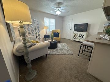 Benton apartment for rent - A living room with a white couch and a grey floor lamp.