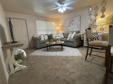 Little Rock apartment for rent - A living room with a grey couch and a white rocking chair.