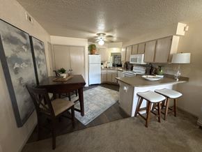 Little Rock apartment for rent - A kitchen with a table and chairs in the middle of the room.