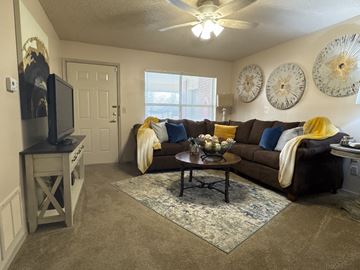 Little Rock apartment for rent - A living room with a brown couch and a ceiling fan.