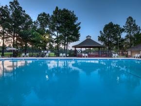 Texarkana apartment for rent - A pool with a gazebo and trees in the background.