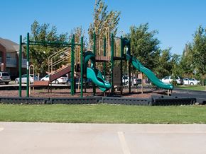 Norman apartment for rent - A playground with a green slide and a brown wooden structure.
