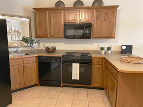 Rogers apartment for rent - a kitchen with black appliances and wooden cabinets