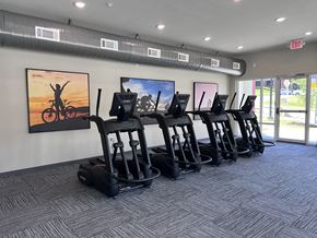 Fayetteville apartment for rent - A gym with treadmills and a painting of a person on a bike on the wall.