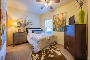Edmond apartment for rent - a bedroom with a bed and a dresser and a ceiling fan