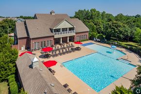 Edmond apartment for rent - a large swimming pool with umbrellas and a building with a resort style pool
