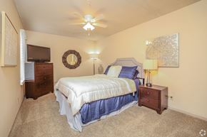 Owasso apartment for rent - a bedroom with a bed and a ceiling fan